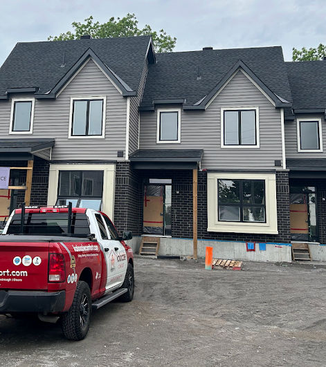 Kaloozie Comfort work truck at an Ottawa new construction site — professional siding installation on new townhomes